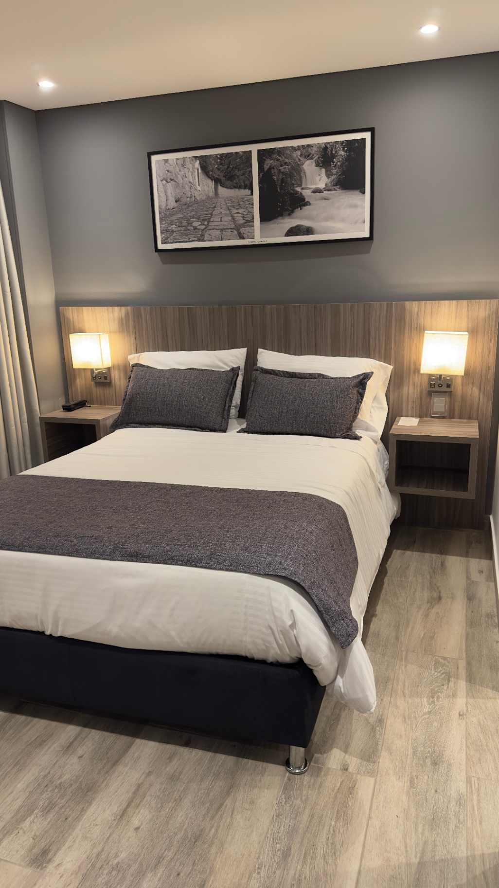 Habitación matrimonial del Hotel Santino con cama amplia, luz cálida y piso en madera