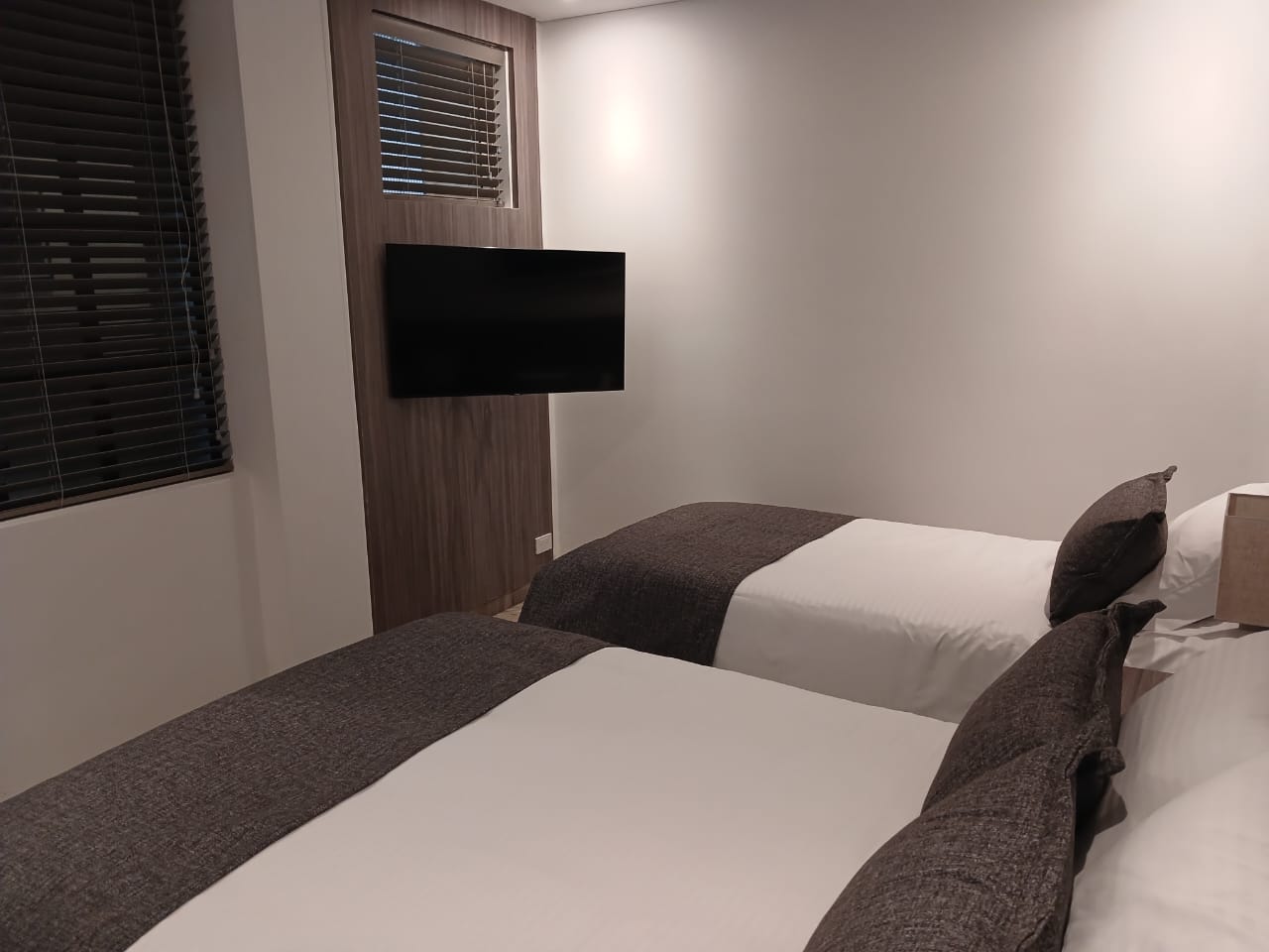 Smart TV de 43 pulgadas frente a las camas en la habitación triple del Hotel Santino