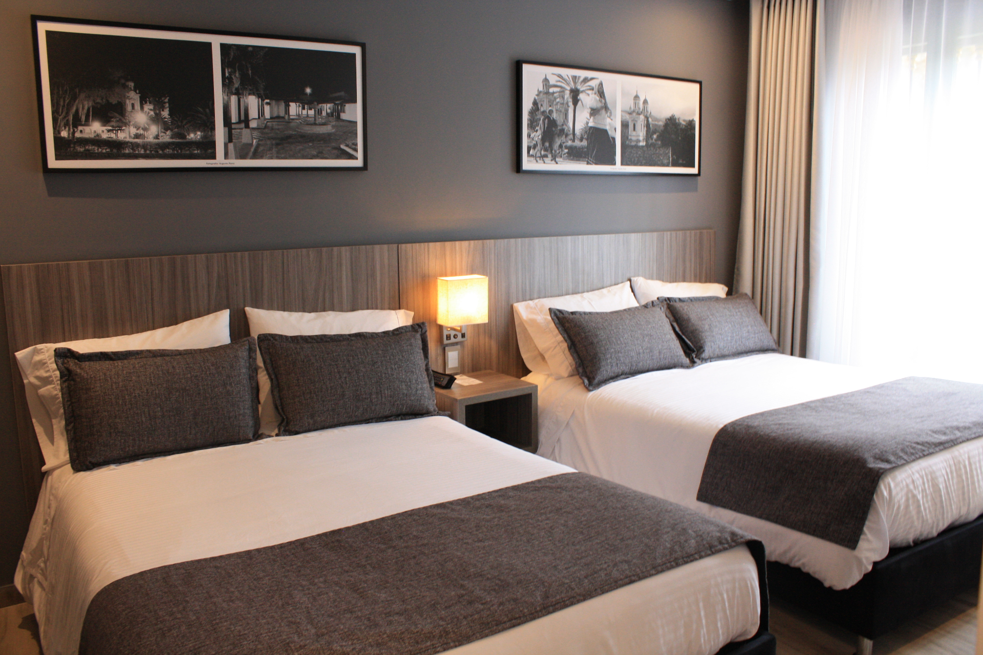 Habitación cuádruple del Hotel Santino con dos camas dobles y decoración contemporánea