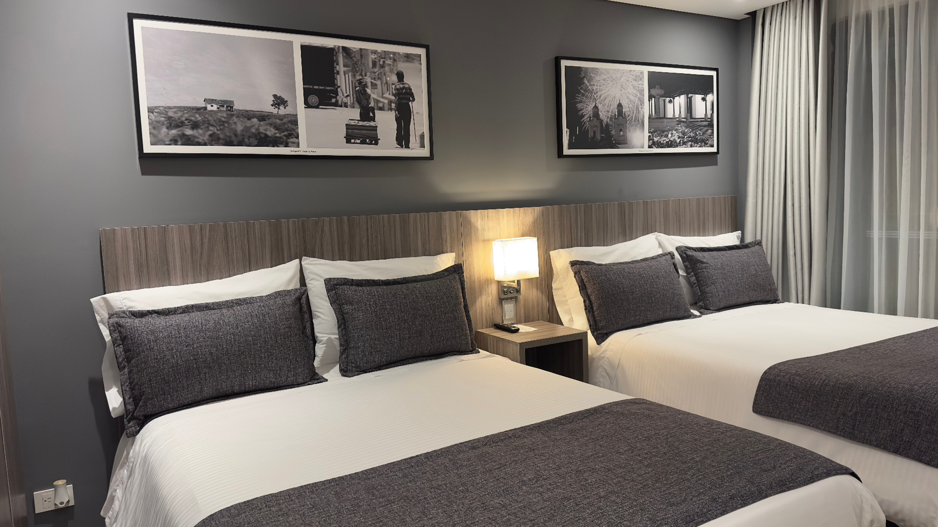 Habitación con dos camas dobles y cuadros decorativos en el Hotel Santino