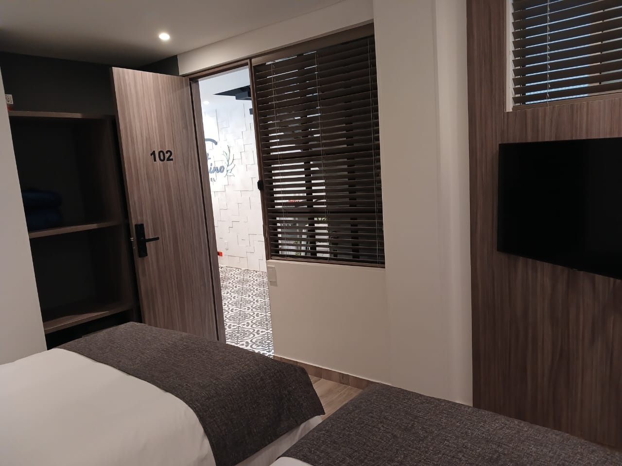 Acceso a la habitación triple 102 del Hotel Santino con closet de cortesía